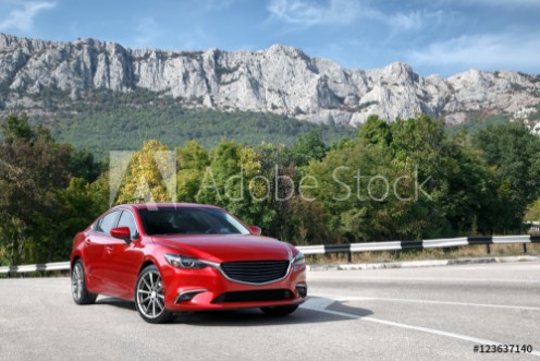 Picture of Red car standing on the road near mountains at daytime